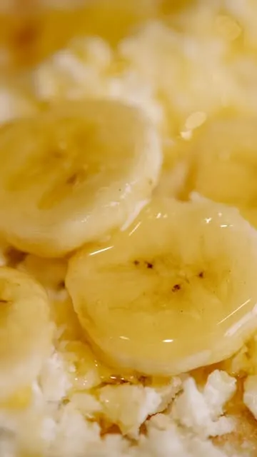 Fette di banana con miele e ricotta su una manoucé calda